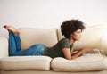 Comfortable and working. a young woman relaxing at home on the weekend while working on her laptop. Royalty Free Stock Photo