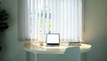 Comfortable workplace with computer tablet, coffee cup and books beside the window with sun light shine through curtain. Royalty Free Stock Photo