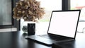 Comfortable workplace with white screen laptop, coffee cup and potted plant. Royalty Free Stock Photo