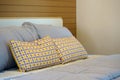 Comfortable yellow and brown geometric pattern cushions with grey pillows on the bed Royalty Free Stock Photo
