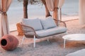 Comfy couch, table, and curtain at the beach