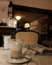 A comfy italian cafe with traditional cappuccino and a newspaper