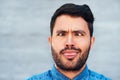 Comic, crossed eyes and man with tongue out, silly and portrait outside by brick wall. Male comedian, funny and making Royalty Free Stock Photo