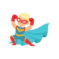 Comic happy kid in superhero costume, red mask and gloves, blue cape developing in the wind, posing and showing muscles.