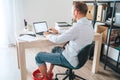 Comic modern home office situation. Businessman have a video call chatting on laptop and soaring his feet in Foot hot Bath under Royalty Free Stock Photo