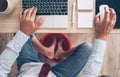 Comic modern office table top view shot. Businessman typing on laptop keyboard, using a PC mouse and soaring his feet in Foot hot Royalty Free Stock Photo