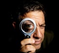 Comic portrait of a man holding a magnifying glass in front of his eye