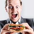 Comical man eating sandwich with funny expression Royalty Free Stock Photo