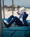 Comical man in suit and funny mask doing sports at the area near beachfront Royalty Free Stock Photo