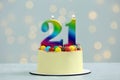 Coming of age party - 21st birthday. Delicious cake with number shaped candles on white table against blurred lights Royalty Free Stock Photo