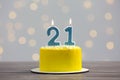 Coming of age party - 21st birthday. Delicious cake with number shaped candles on wooden table against blurred lights Royalty Free Stock Photo