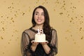 Coming of age party - 18th birthday. Woman holding delicious cake with number shaped candles and looking at falling confetti Royalty Free Stock Photo