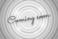 Coming soon advertisement text on white circle retro cinema screen. Black title on old movie background. Promotion Royalty Free Stock Photo