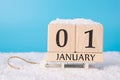 2021 is coming soon concept. Close up photo of wooden cube calendar showing the first day of new year standing on little white Royalty Free Stock Photo