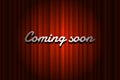 Coming soon handwrite title on closed red silky luxury theater curtain background with spotlight beam illuminated Royalty Free Stock Photo