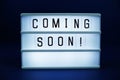 Coming Soon letterboard text on LED Lightbox on blue background Royalty Free Stock Photo