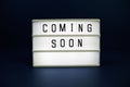 Coming Soon letterboard text on LED Lightbox on blue background Royalty Free Stock Photo