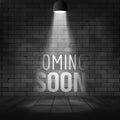 Coming soon message illuminated with light spotlight projector. Brick wall and stage realistic Royalty Free Stock Photo