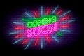 Coming soon with rays neon sign. Realistic neon effect on a brick wall.