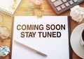 Coming Soon Stay Tuned wording on a white paper on wooden office background Royalty Free Stock Photo