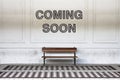 Coming soon written on a wall above a wooden bench - concept image