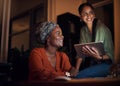 Coming together to conquer the deadline. two businesswomen working together on a computer in an office at night. Royalty Free Stock Photo