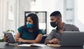 Coming together to get their startup going again. two businesspeople working together on a digital tablet in an office. Royalty Free Stock Photo