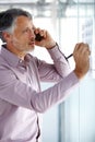 Coming up with the best strategy for his client. A mature businessman talking on his cellphone while writing something Royalty Free Stock Photo