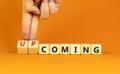 Coming or upcoming symbol. Concept words Coming and Upcoming on wooden cubes. Businessman hand. Beautiful orange table orange Royalty Free Stock Photo