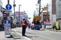 A commander is directing the traffic for repairing the road in Fukushima city, Japan