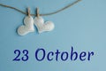 Commemorative date October 23 on a blue background with white hearts with clothespins, flat lay. Holiday calendar