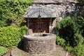 A commemorative well built from natural stone and ornate iron work in the grounds of Dunster Priory Church, Somerset, England Royalty Free Stock Photo