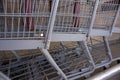 Commerce: Three gray grocery carts awaiting use.