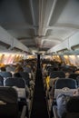 Commercial aircraft cabin with rows of seats down the aisle