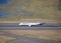 Commercial aircraft parked atop a sunlit tarmac of an airport runway