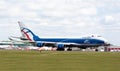 Commercial aircraft is parked on the grassy tarmac in an airport setting in London, UK. Royalty Free Stock Photo