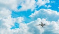 Commercial airline flying on blue sky and white fluffy clouds. Under view of airplane flying. Passenger plane after take off or Royalty Free Stock Photo