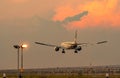 Commercial airline. Passenger plane landing at airport with beautiful sunset sky and clouds. Arrival flight. Airplane flying Royalty Free Stock Photo