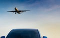 Commercial airline. Passenger plane landing approach blue SUV car at airport with blue sky and clouds at sunset. Arrival flight. Royalty Free Stock Photo