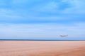 Commercial airplane above sea in summer season and clear blue sky over beautiful scenery sandy beach background, Concept business Royalty Free Stock Photo