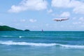 Commercial airplane above sea in summer season and clear blue sky over beautiful scenery sandy beach background, Concept business Royalty Free Stock Photo