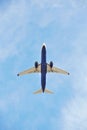 Commercial airplane captured from below as it climbs into the vast blue sky, showcasing its underbelly and jet engines Royalty Free Stock Photo