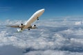 Commercial airplane flying above clouds and clear blue sky over Royalty Free Stock Photo