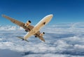 Commercial airplane flying above clouds and clear blue sky over Royalty Free Stock Photo