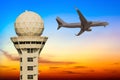 Commercial airplane flying over airport control tower