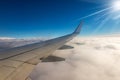 Commercial Airplane Flying over the Clouds - Looking through the Plane Window Royalty Free Stock Photo