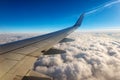 Commercial Airplane Flying over the Clouds - Looking through the Plane Window Royalty Free Stock Photo