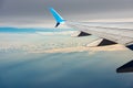 Commercial airplane flying over the clouds and Mediterranean Sea Royalty Free Stock Photo