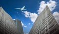 Commercial airplane flying over tall skyscrapers in the city. Bottom view. Royalty Free Stock Photo