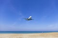 Commercial airplane landing above sea and clear blue sky over beautiful scenery nature background location at mai khao beach Royalty Free Stock Photo